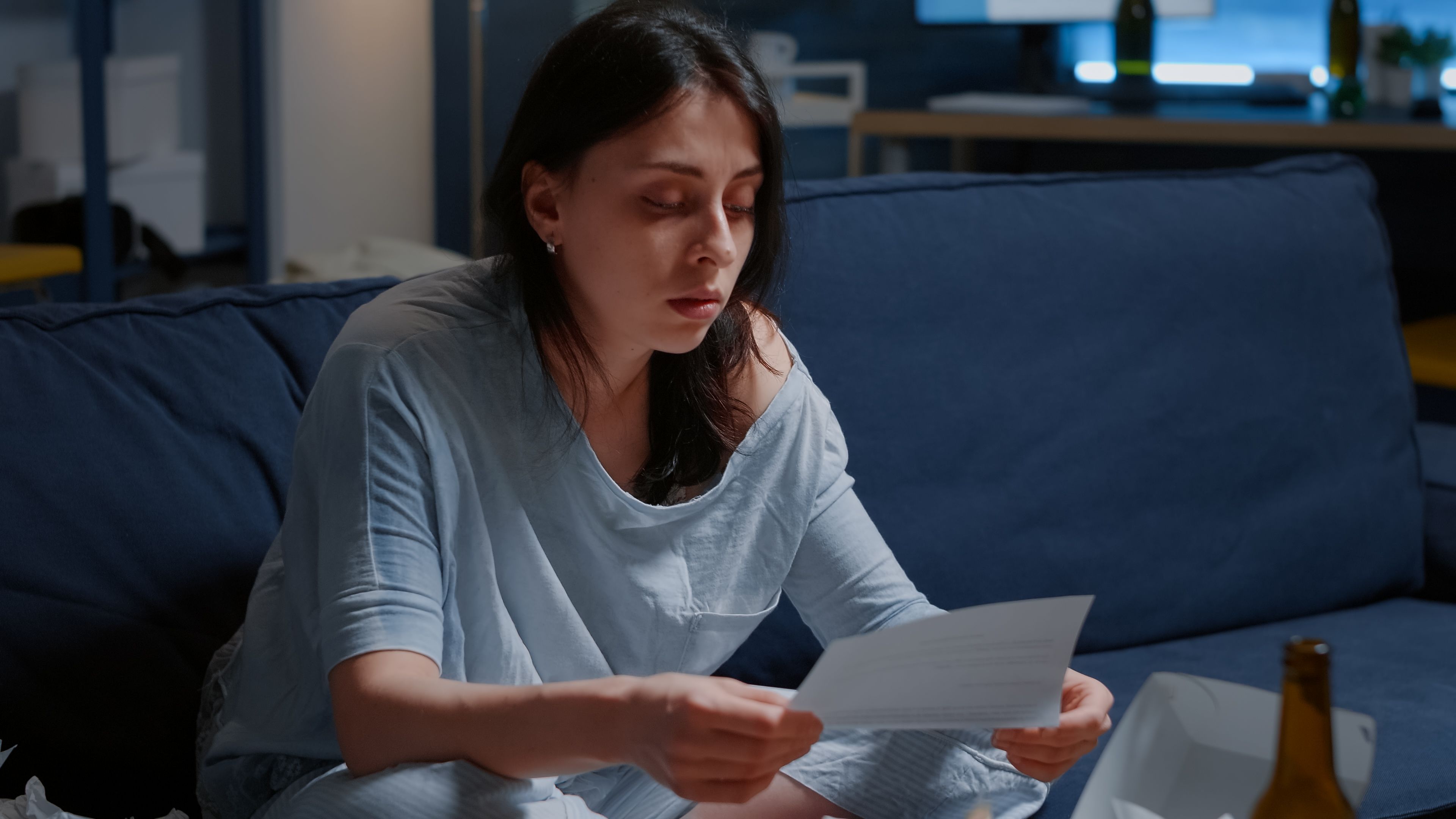 A worried woman sitting and reading an eviction notice