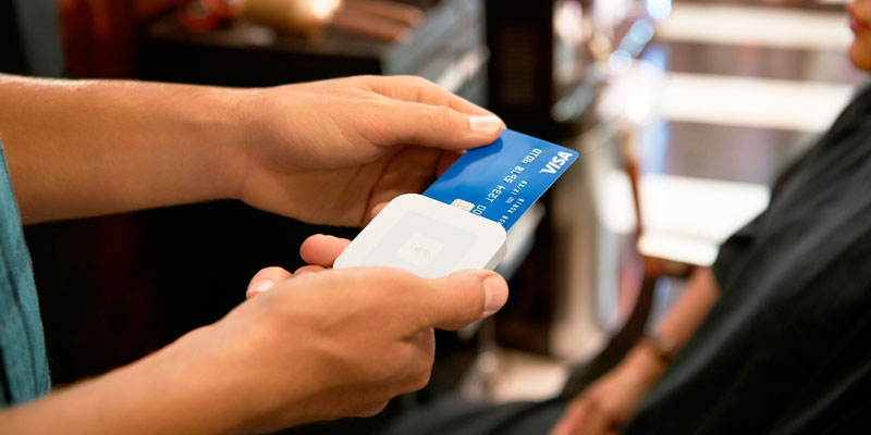 A credit card is dipped in a Square reader.