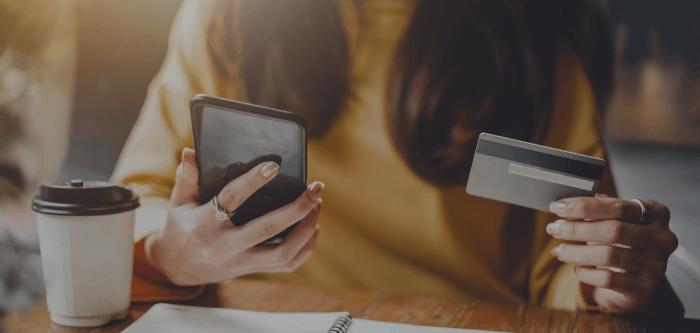 image of hands holding mobile phone and bank card