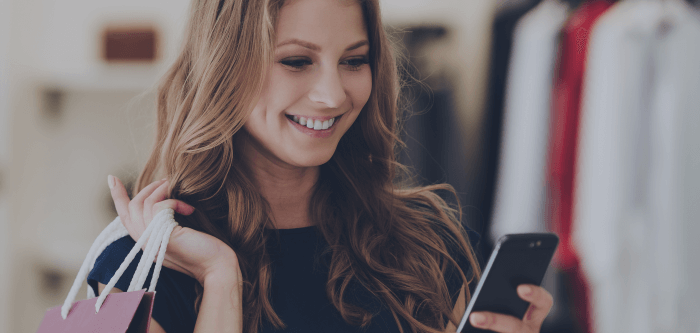 Woman holding a shopping bag and a mobile phone