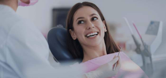 women smiling in chair at dentist surgery