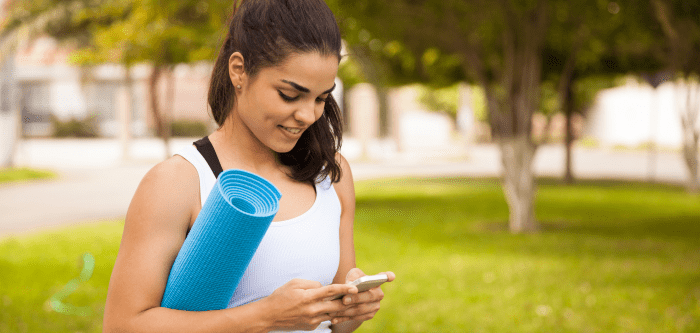 woman with yoga mat and mobile phone