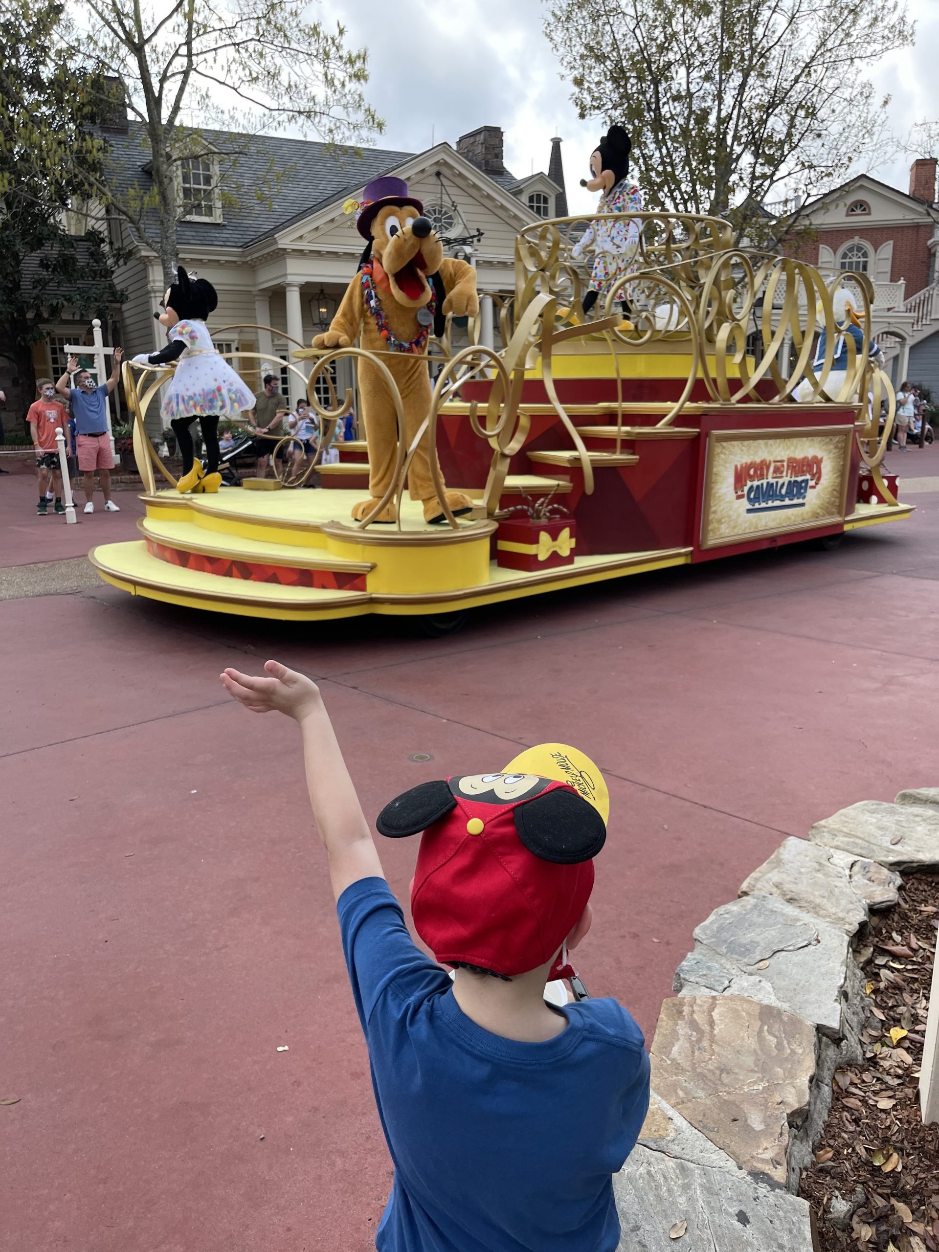 Tommy's son waves to Pluto during parade.