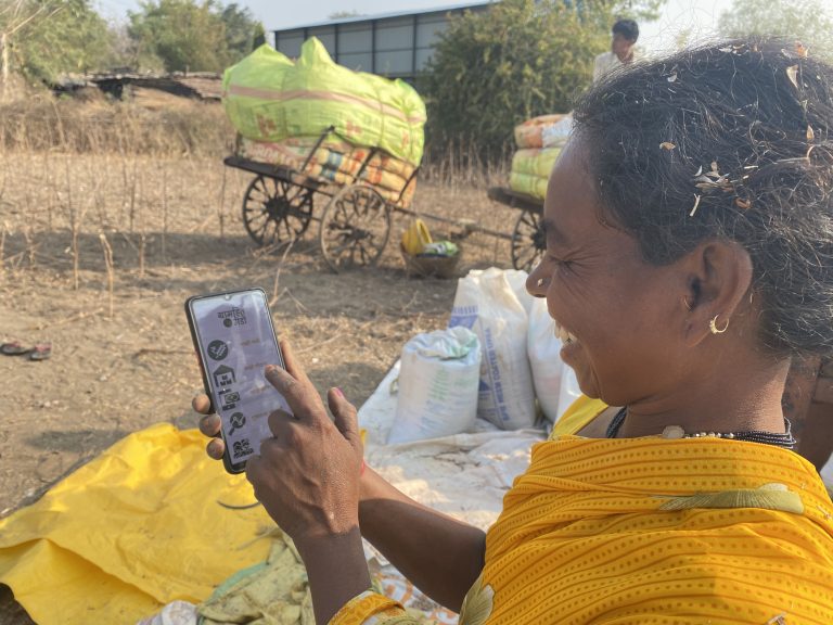 A woman farmer using the GramHeet Mandi mobile app to sell her stored produce