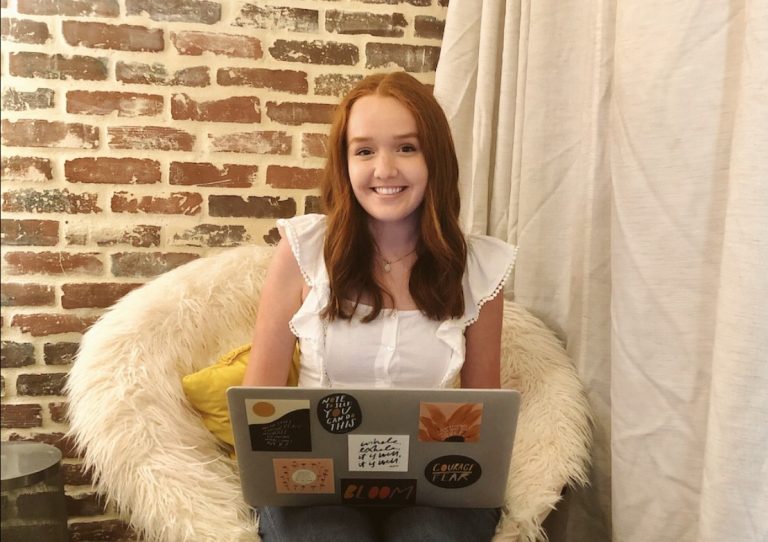 A young woman working on her laptop from home.