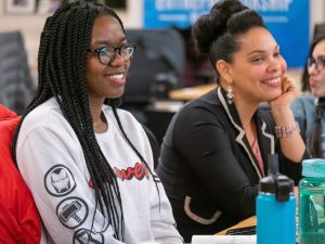 Two women smiling while sitting at a table