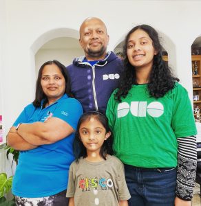 Family of four posed together wearing Cisco and Duo shirts.