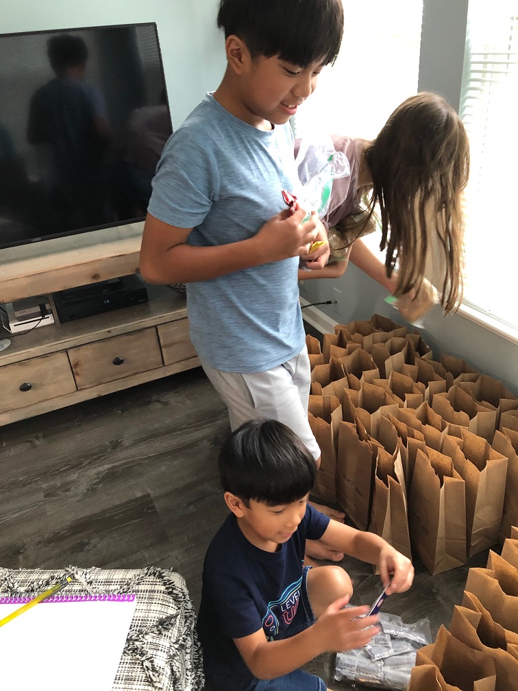 Maria's family helps to package meals.