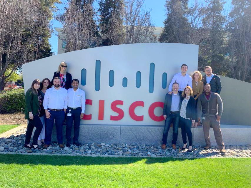 Team in front of Cisco sign.