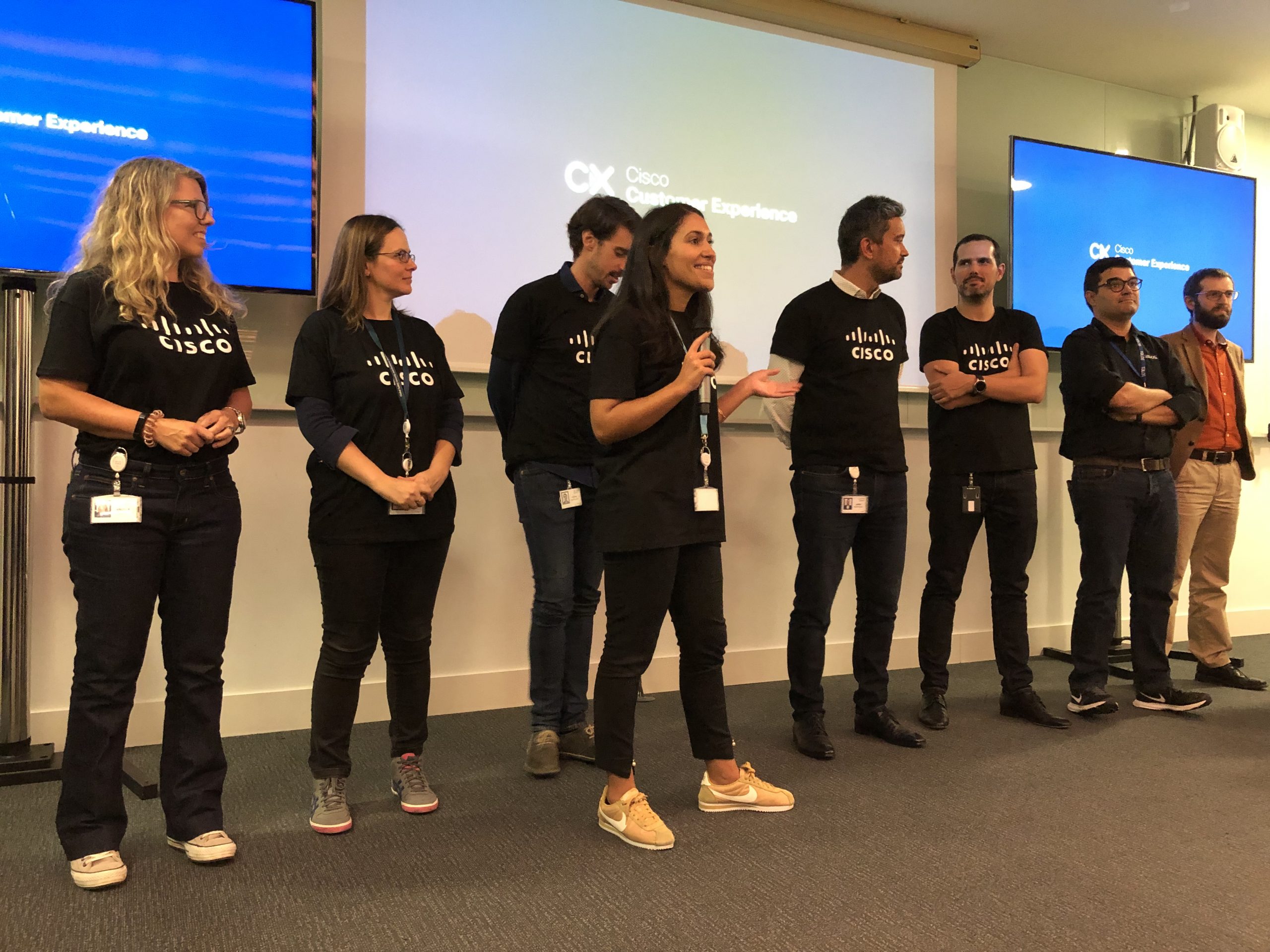 Group wearing Cisco shirts speaks to audience.