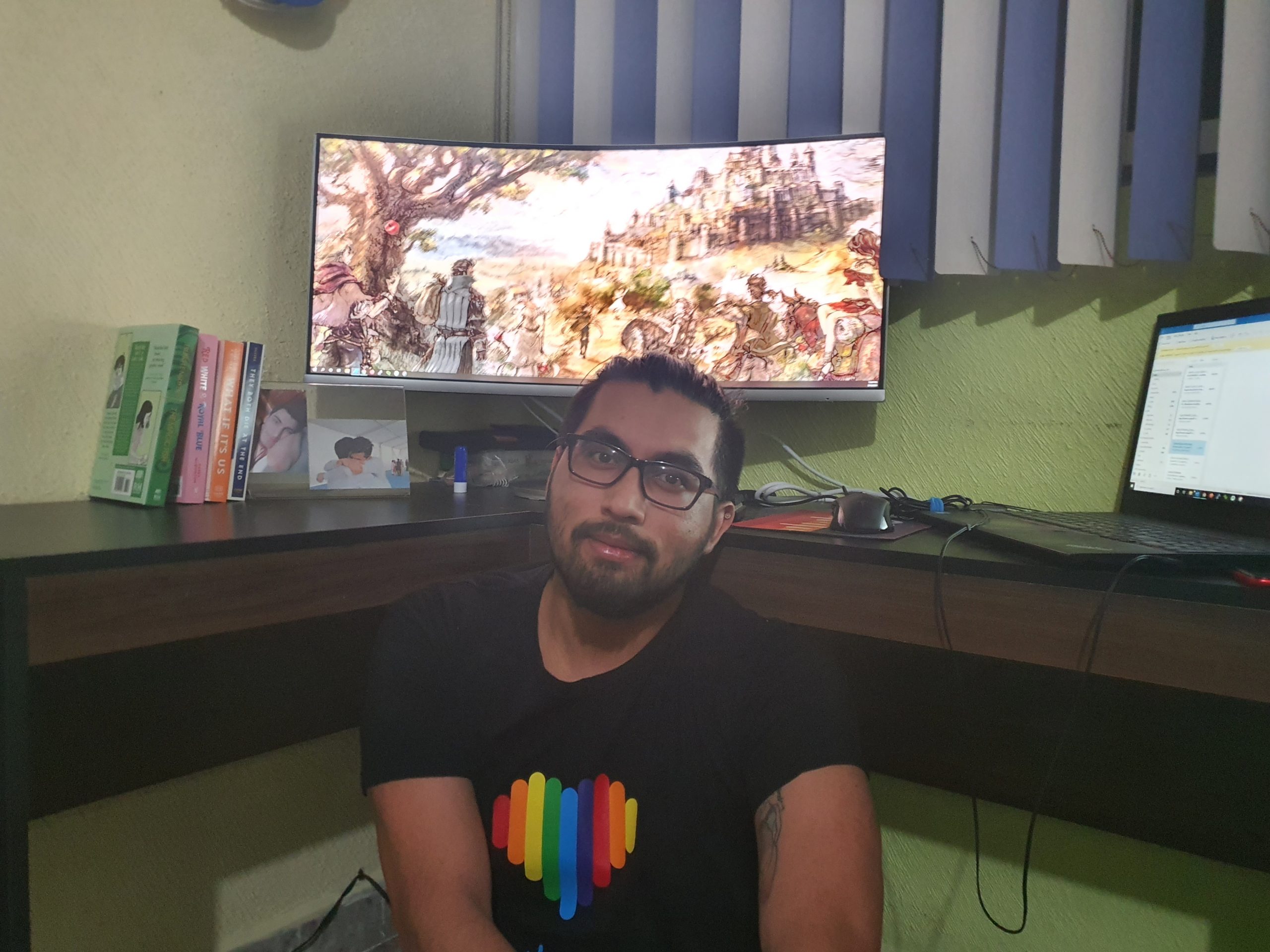 Jesus sitting in front of computer in pride shirt