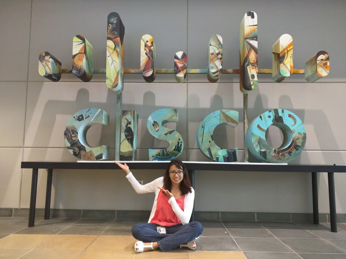 Liz sitting in front of Cisco sign 