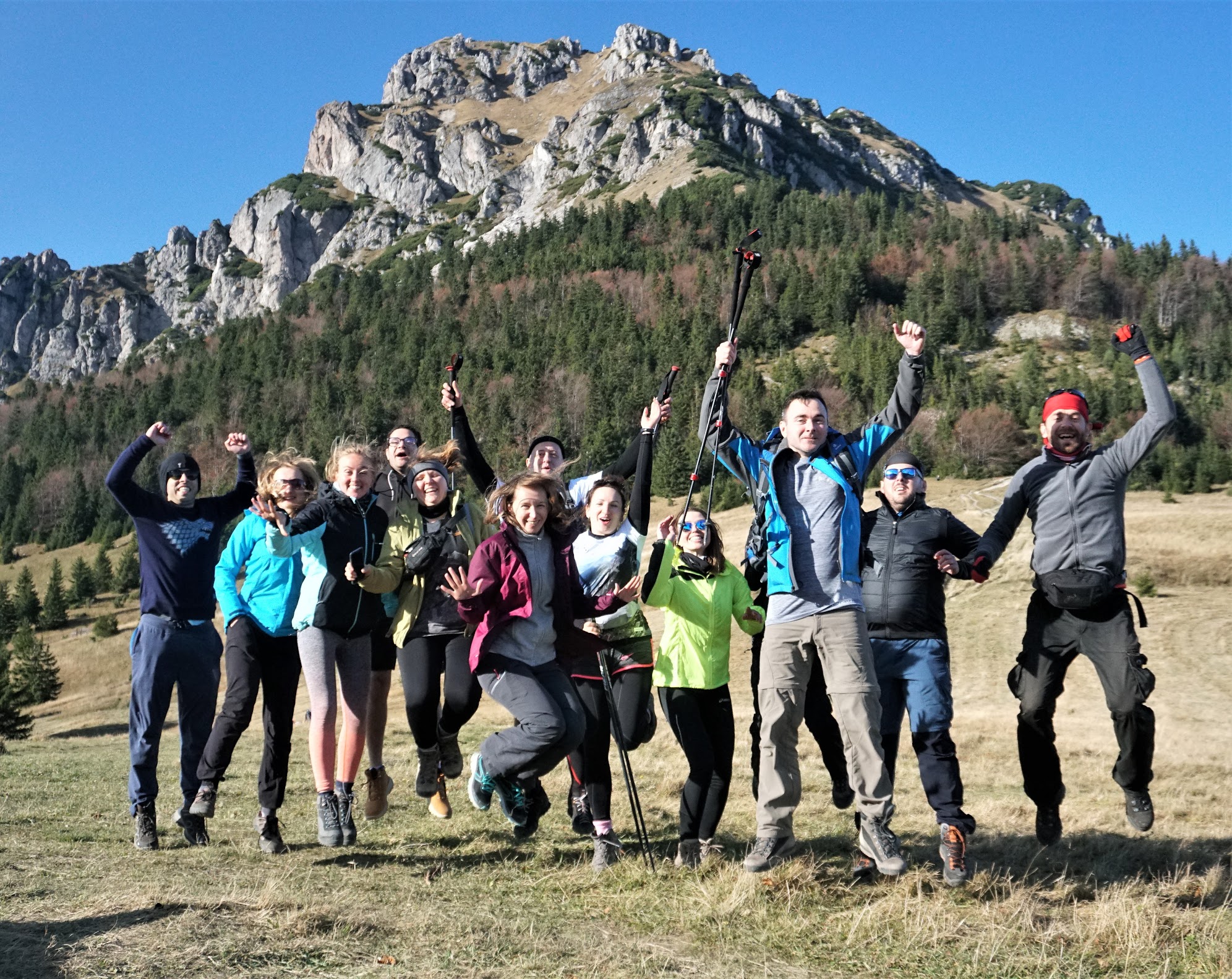 Tatiana and team on a hike, jumping in the air while their picture is taken. 