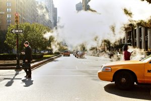 two pedestrians walking in city street with yellow taxi cab driving by