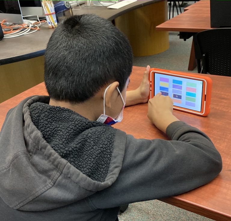 Project READ student using a onetab (orange device) onsite.