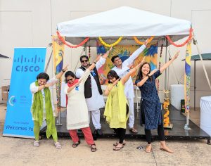 Group of people doing Indian dance in front of tent.