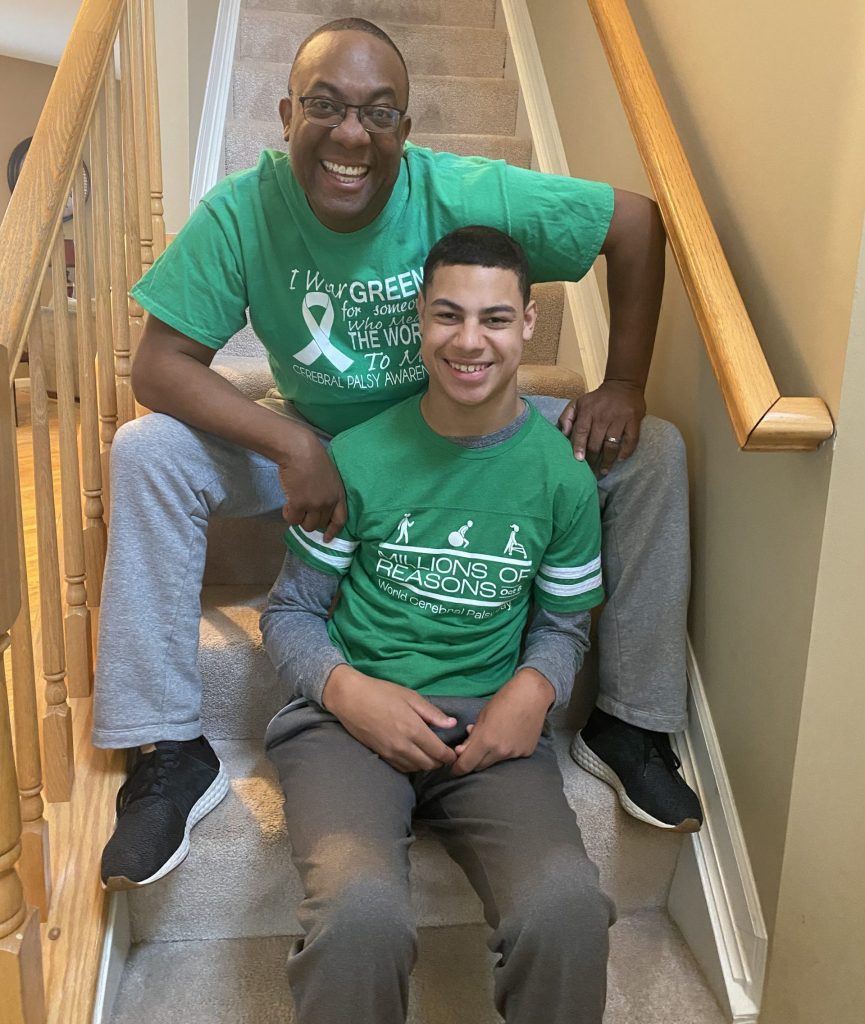 Two men sitting on the stairs together wearing matching green shirts