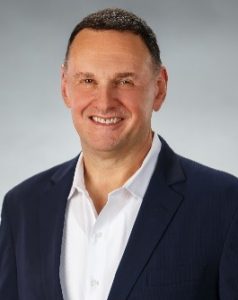 A man wearing a white shirt and dark blazer