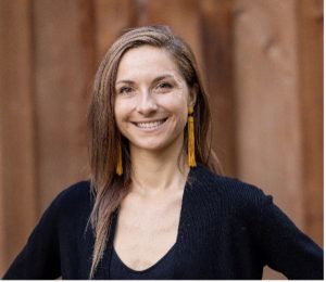 A woman smiling wearing black