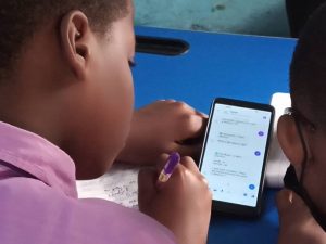 Child reviews work on mobile phone using Darsel chatbot