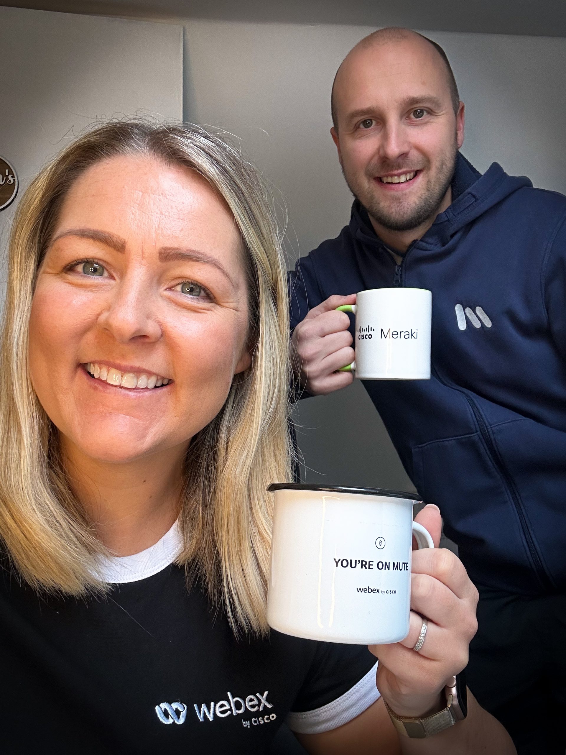 A man and a woman holding up mugs. 