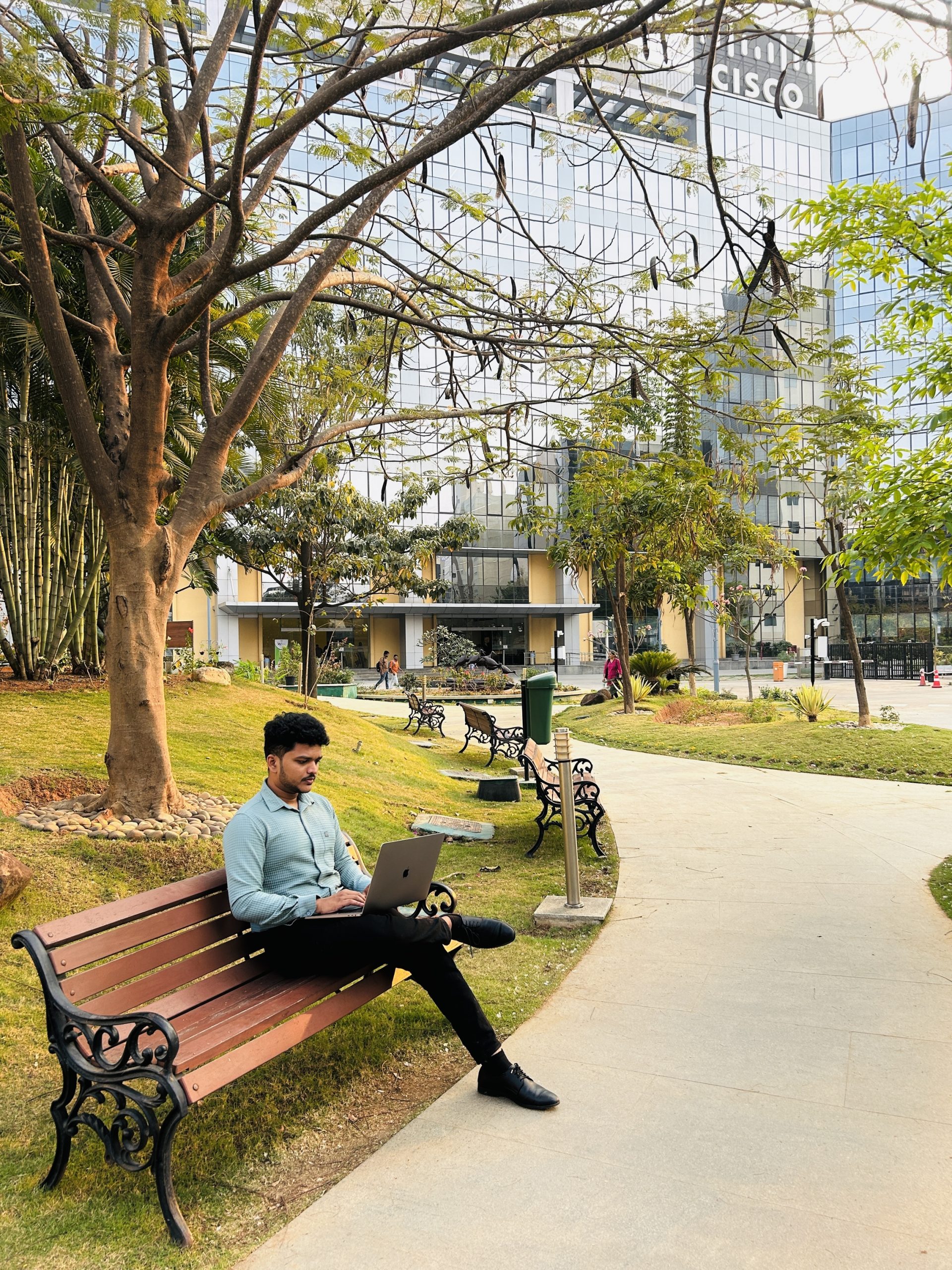 Person sitting on a bench with a laptop.