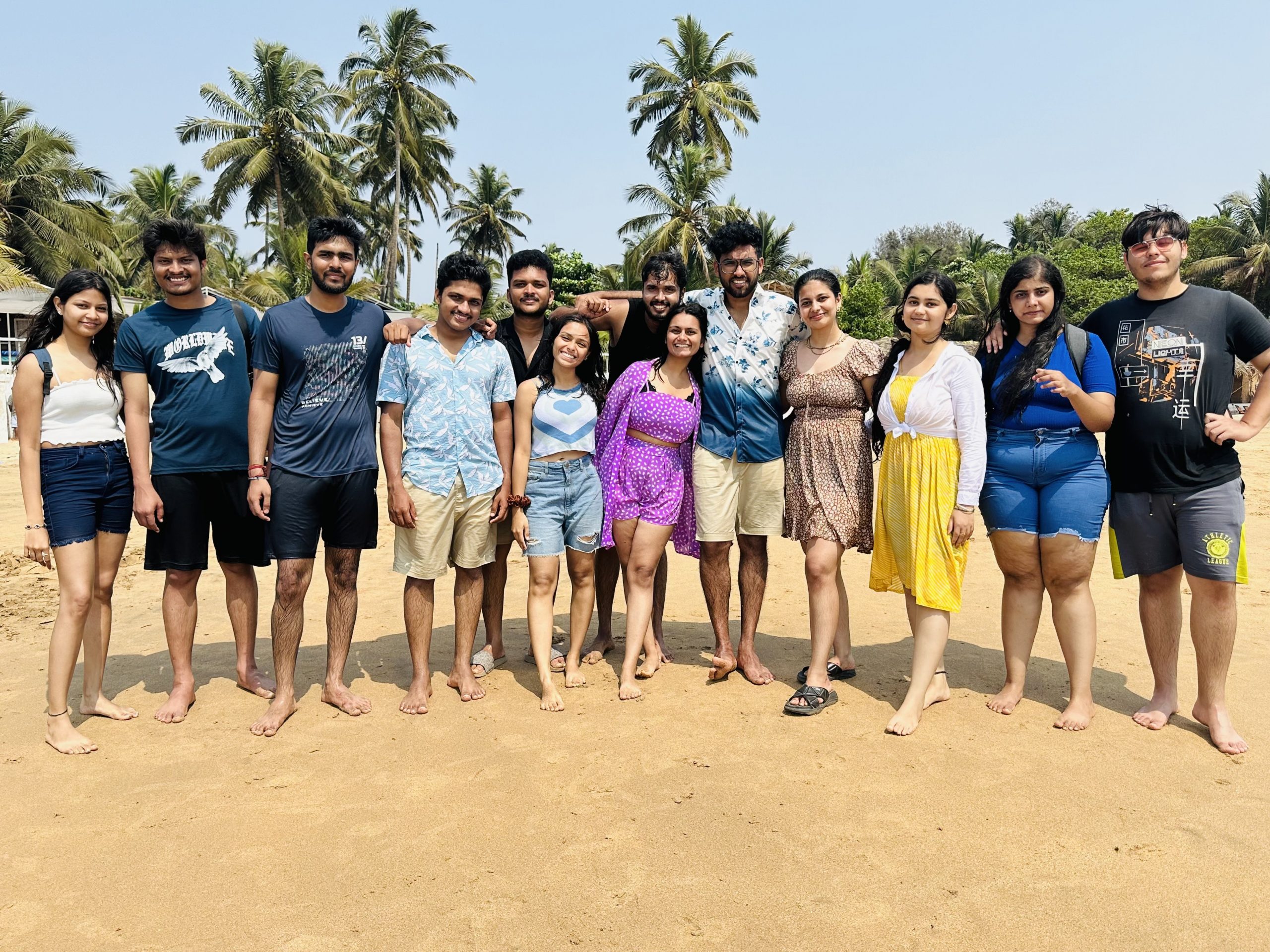 Large group of people standing together at the beach.