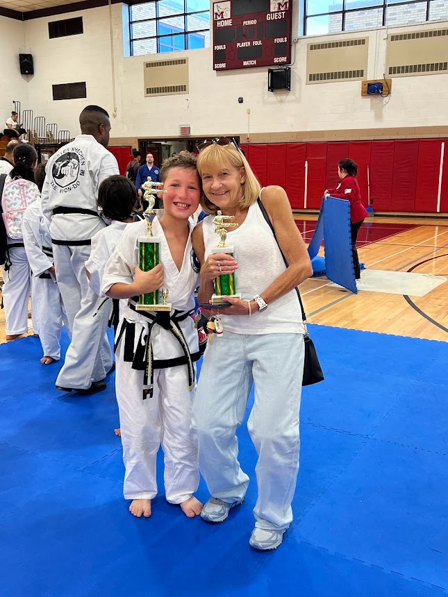 Wendy's mom and son holding trophies.