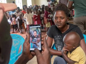 Woman and child authenticating with face recognition on phone