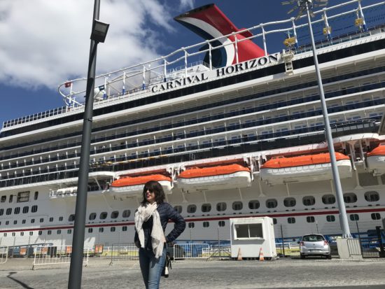 Alejandra smiles in front of a cruise ship.