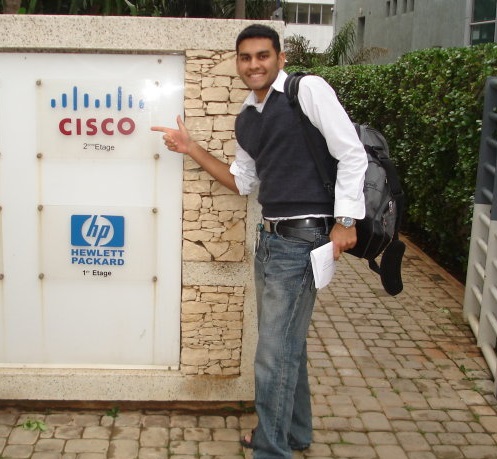 Shalveen pointing to a Cisco sign in Casablanca with French text underneath.