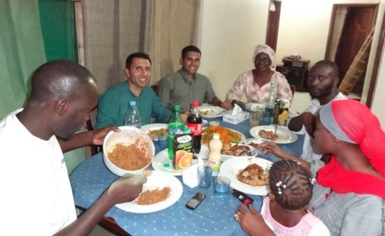 Shalveen sitting with his Cisco family enjoying a meal in Senegal.