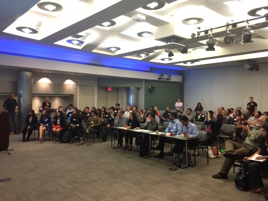 Cisco judges, volunteers, and local high school students watch anxiously as competitors present their ideas