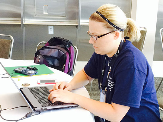 Cisco Networking Academy student Courtney Church uses a rare break at Cisco Live to catch up on homework.