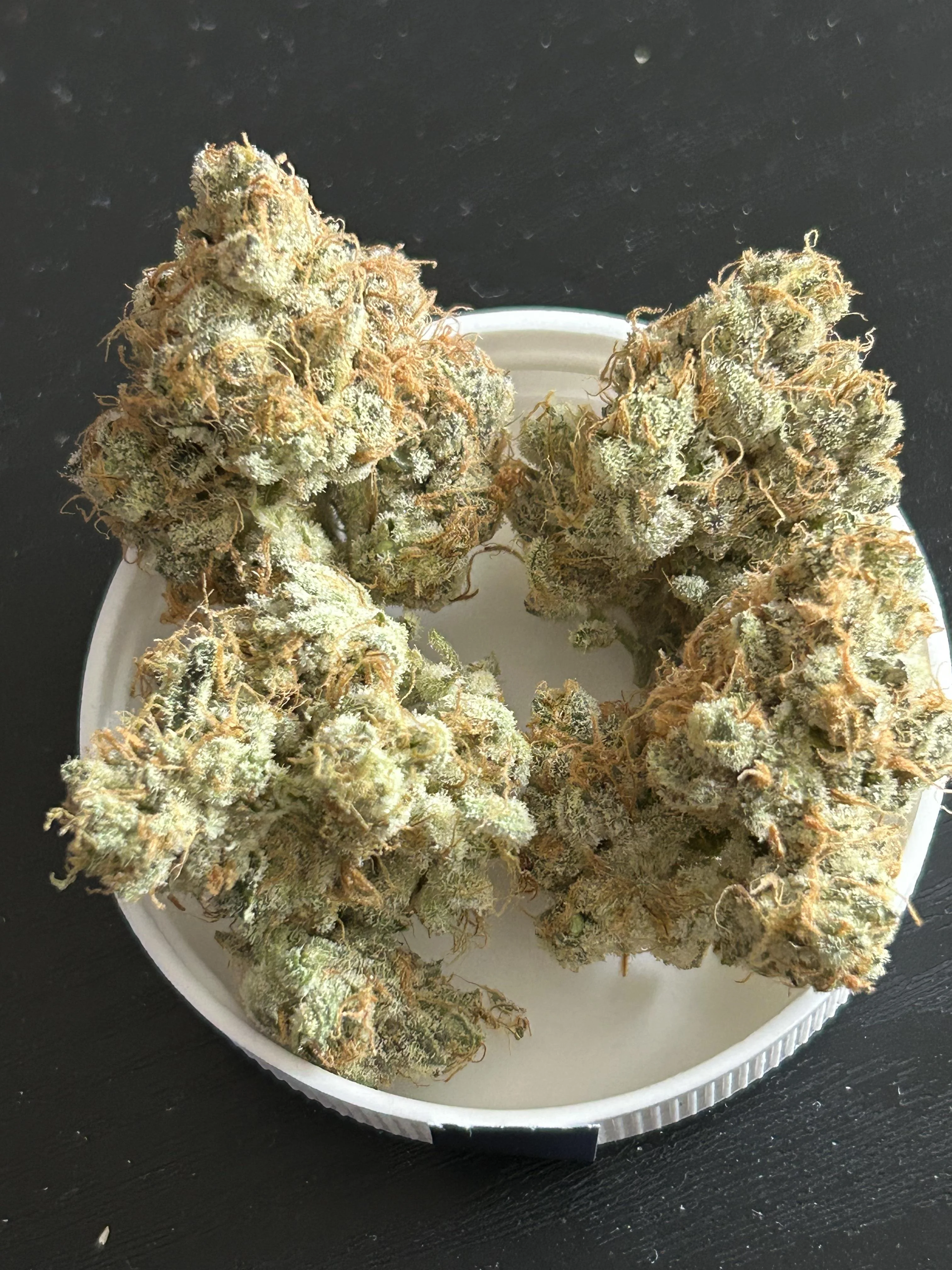 Sugarloaf Pineapple cannabis buds with purple hues and heavy trichomes, sativa-dominant hybrid with tropical aroma