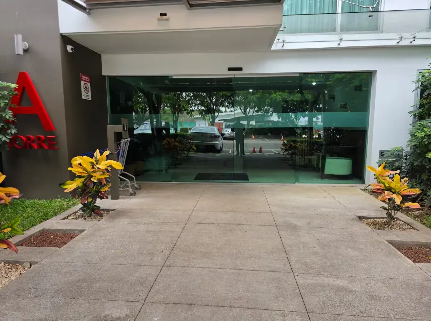 Torre A building entrance with glass doors and landscaped walkway