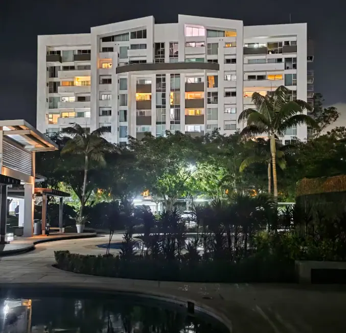 Apartment tower at night overlooking the pool courtyard