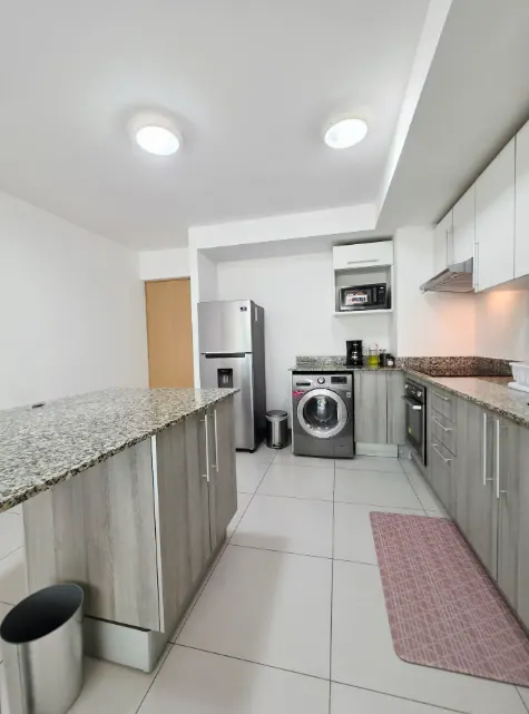 Kitchen island, granite counters, cooktop, and range hood