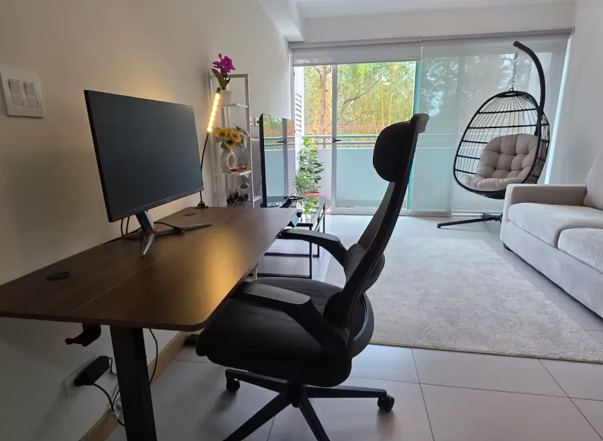 Dedicated workspace desk with monitor overlooking the living room and balcony