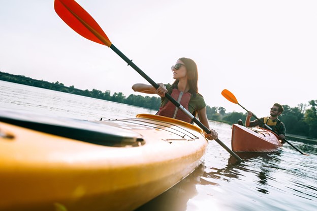 A closeup of a couple kayaking in a lake together.