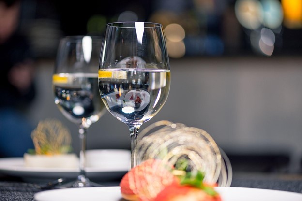 A closeup of dessert and two glasses of water on a restaurant table.