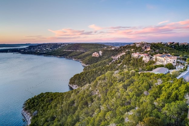 A wide view of some luxury homes on a hill overlooking Lake Travis.