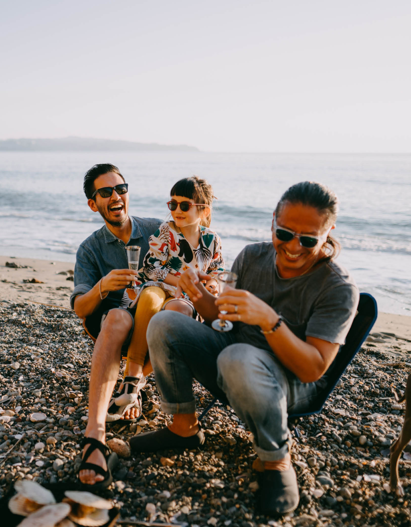 Family Men drinking champagne on beach laughing