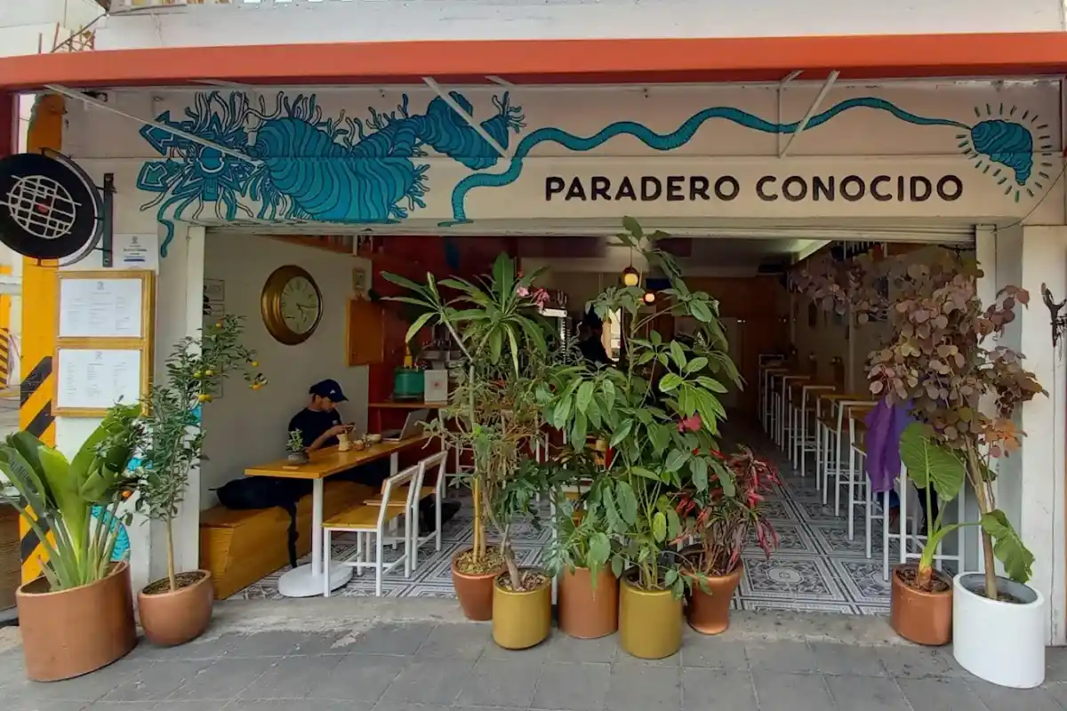 Fachada de un restaurante casual con plantas por fuera