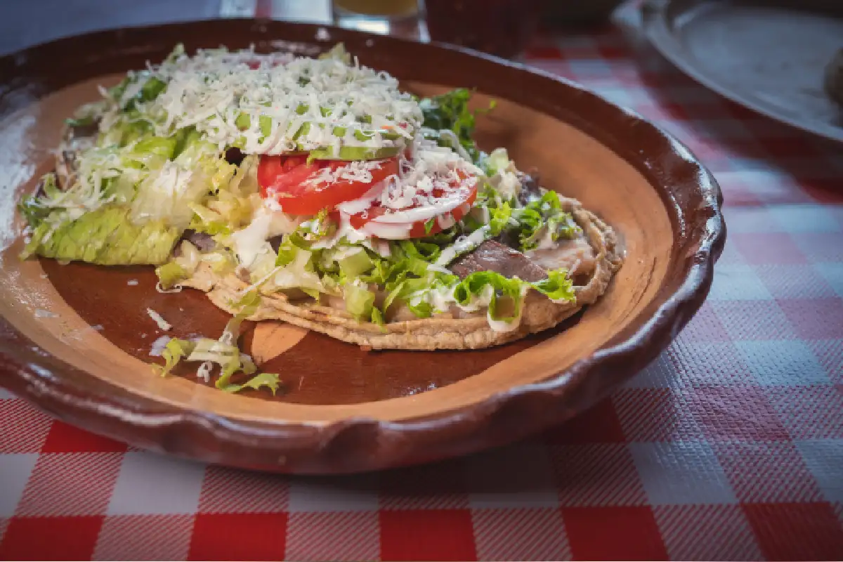 Plato de barro con un huarache con frijoles