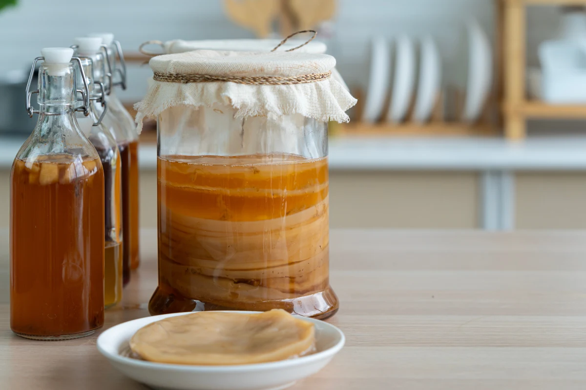 Frascos de vidrio con tela cubierta con kombucha en su interior