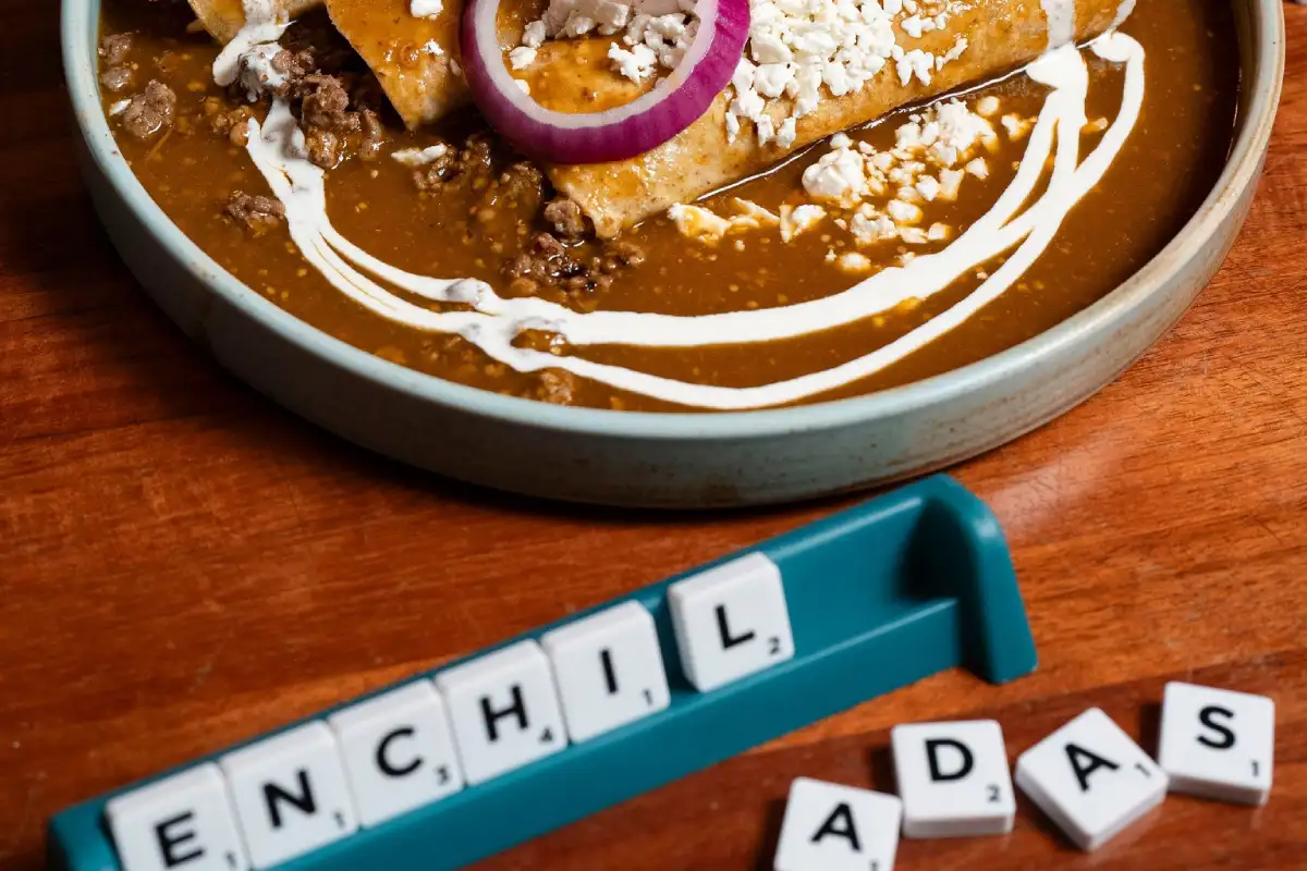 Mesa con enchiladas y una tablero de scrabble