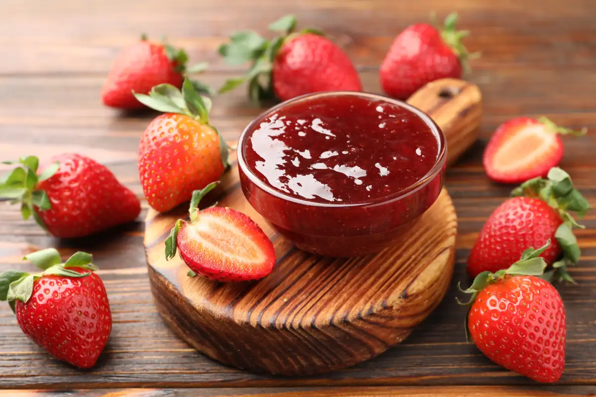 Recipiente de vidrio con mermelada de fresa y fresas frescas 