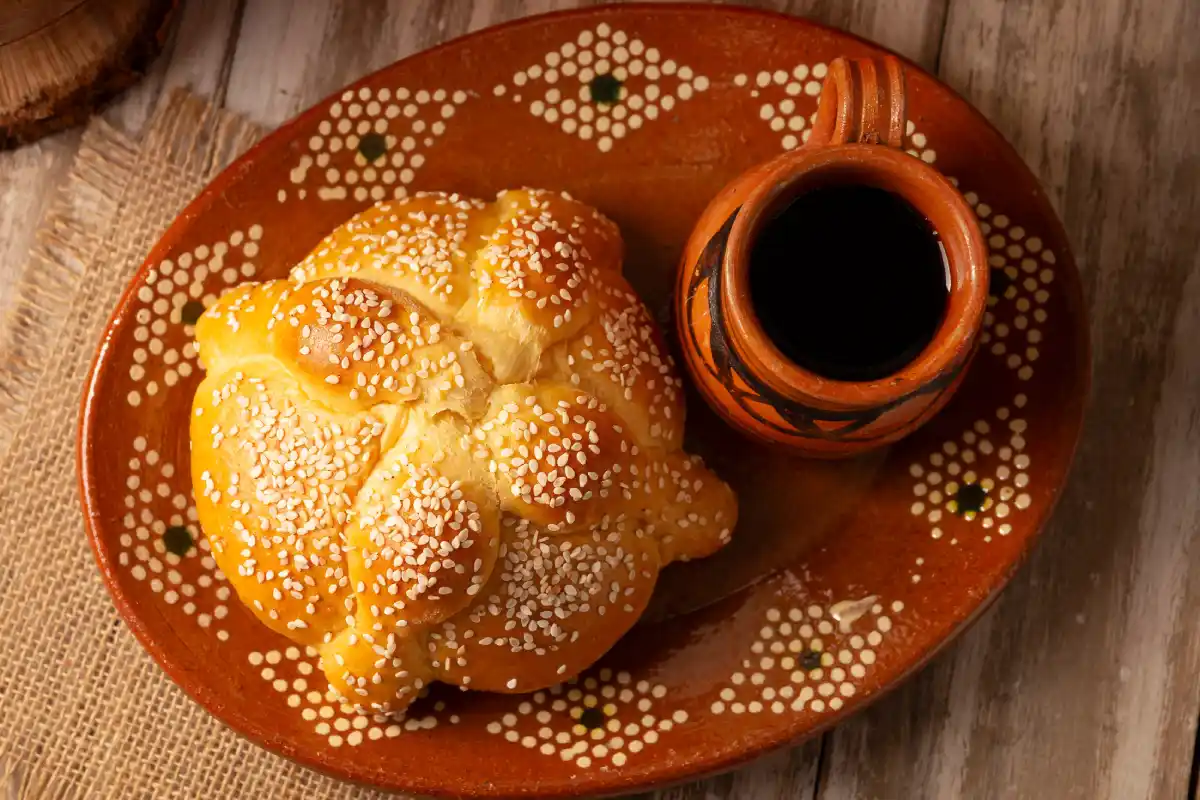Pan de muerto y café de olla en una vajilla de barro