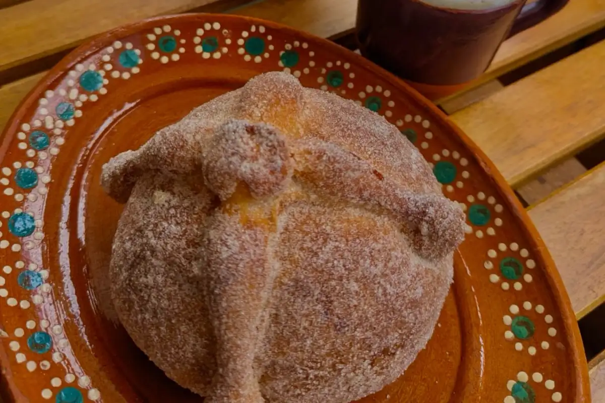 Pieza de pan de muerto sobre un plato de barro